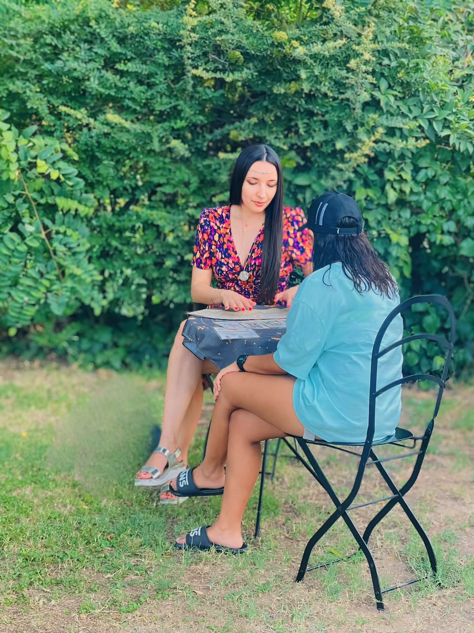 Gisel haciendo una lectura de tarot al aire libre en el jardín
